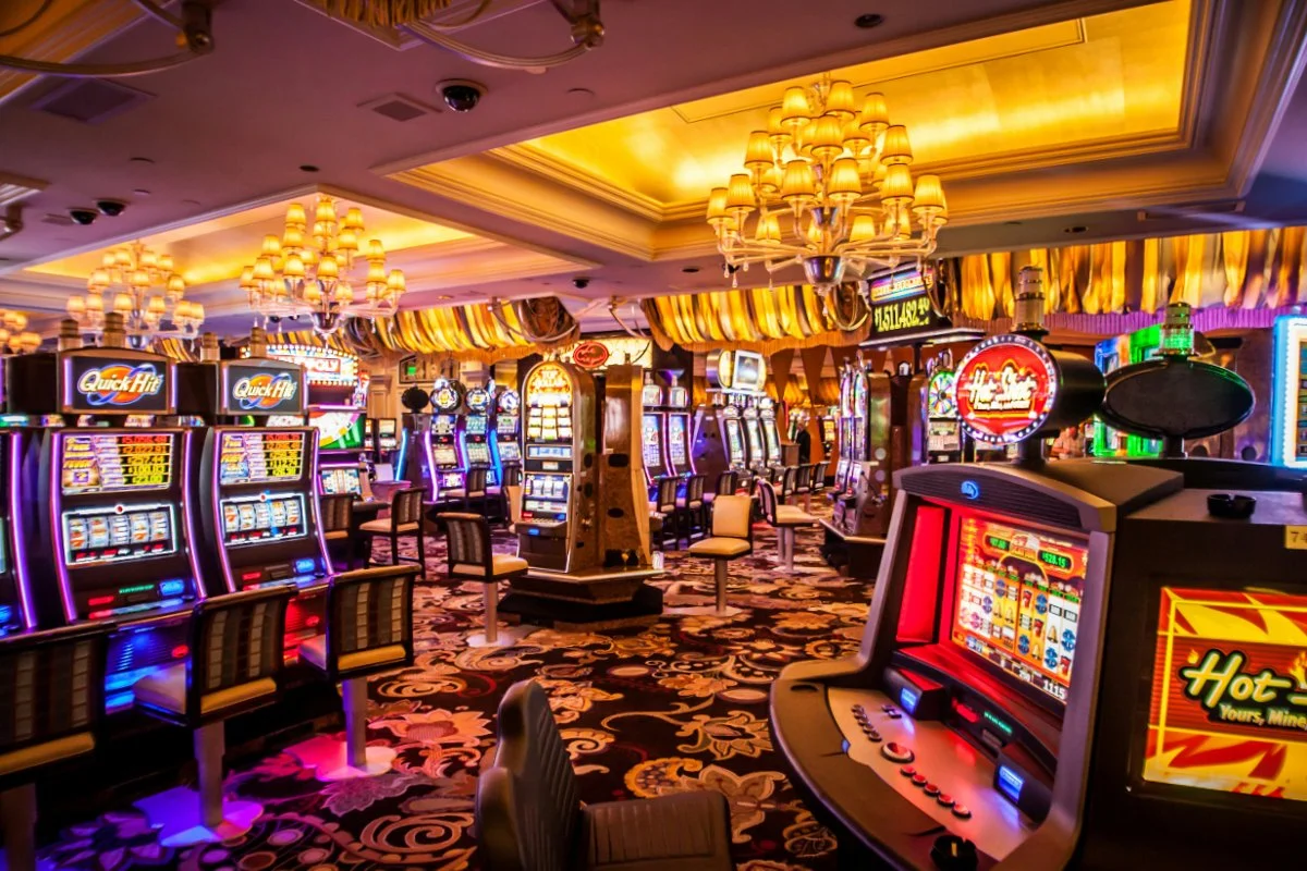 Sala de casino con múltiples máquinas tragamonedas iluminadas